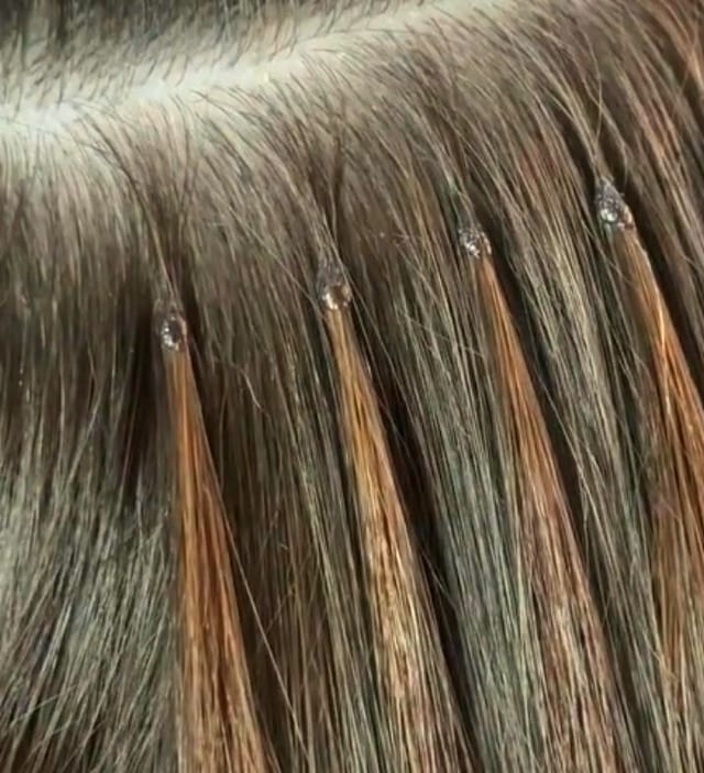 Close-up of freshly applied keratin bond hair extensions on dark brunette hair, demonstrating the strand-by-strand technique used at Sisters' Hair Extensions London Dagenham studio.